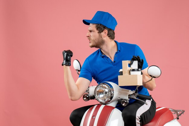 Front view male courier in blue uniform holding coffee on pink color job fast-food delivery service worker work