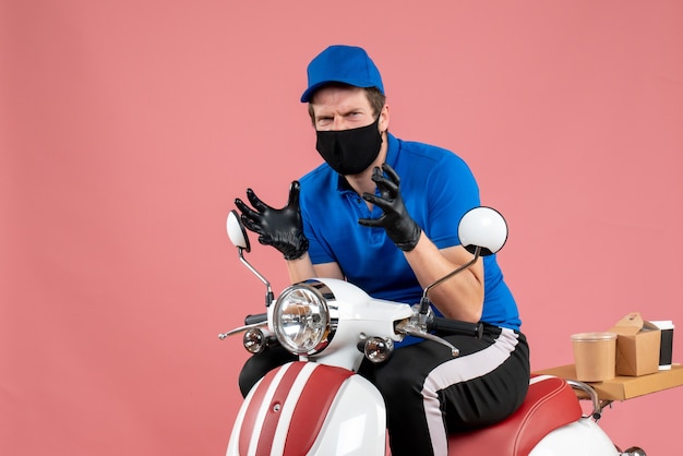 Front view male courier in blue uniform and mask angry on pink food job fast-food service delivery bike virus work covid-