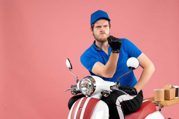 Front view male courier in blue uniform on a pink food bike delivery job color work service fast-food