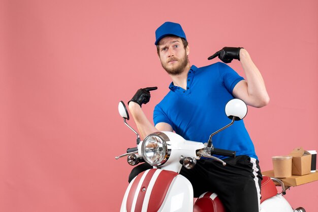 Front view male courier in blue uniform on pink 