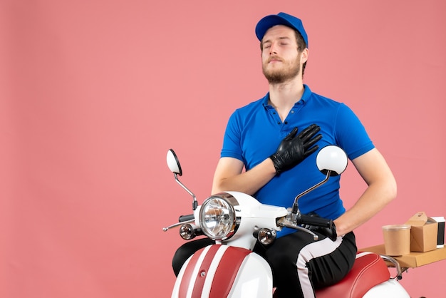 Front view male courier in blue uniform on the pink 