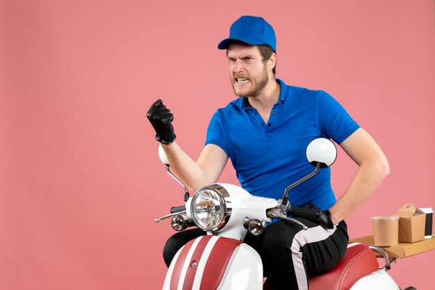 Front view male courier in blue uniform on the pink 