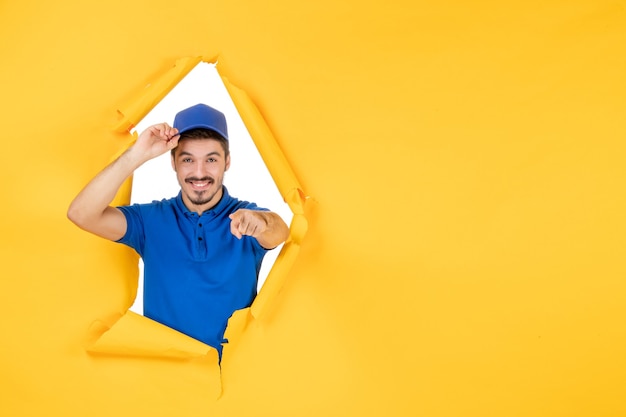 Front view male courier in blue uniform on a yellow space