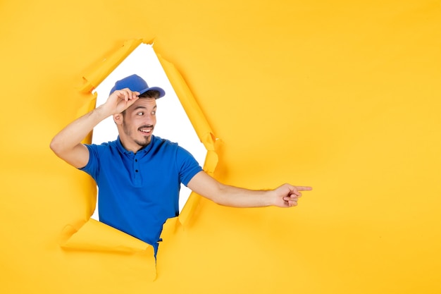 Front view male courier in blue uniform on a yellow space