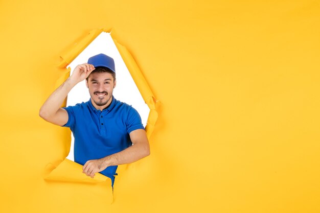 Front view male courier in blue uniform on the yellow space