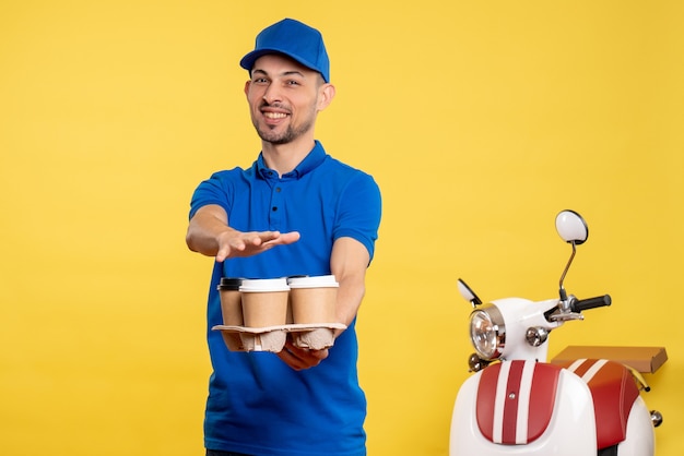 Front view male courier holding delivery coffee on yellow color worker service work emotion job delivery uniform bike