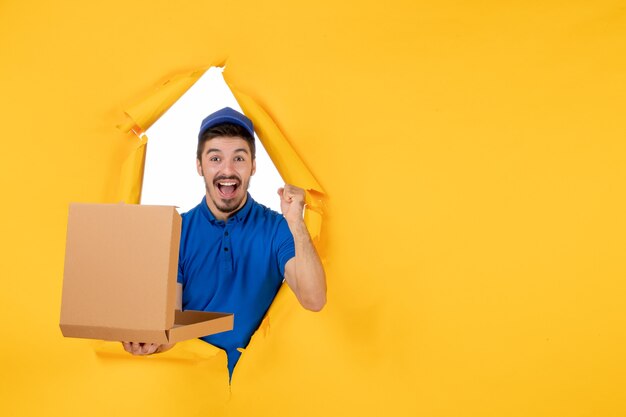 Front view male courier holding opened pizza box on yellow space