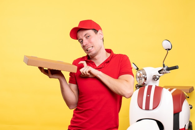 Front view male courier holding pizza box on the yellow work delivery job worker uniform bike color service