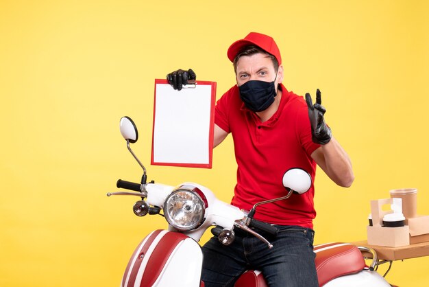 Front view male courier in mask holding file note on yellow 