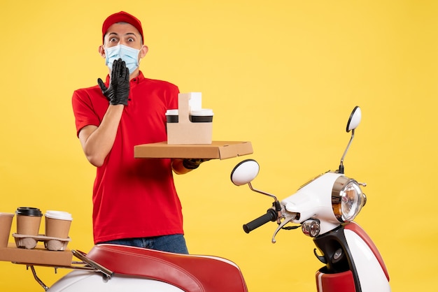 Front view male courier in red uniform with food delivery on the yellow job service pandemic covid- uniform virus color bike