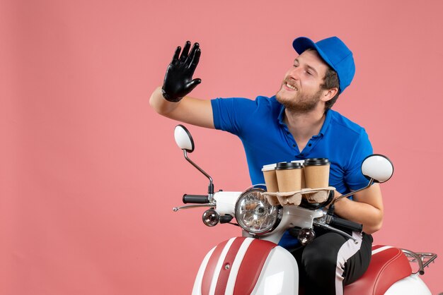 自転車に座って、ピンクのコーヒー カップを保持している正面の男性宅配便