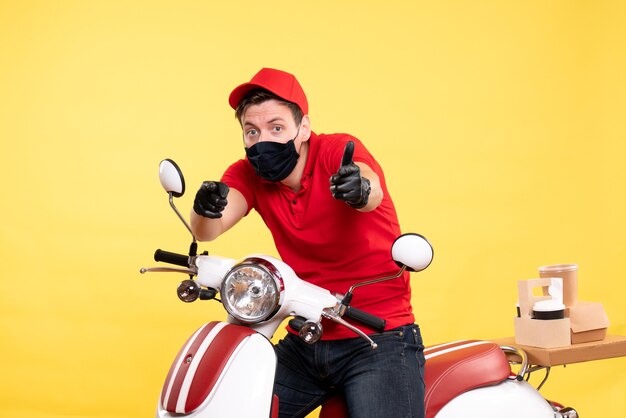 Front view male courier in uniform gloves and mask on yellow 