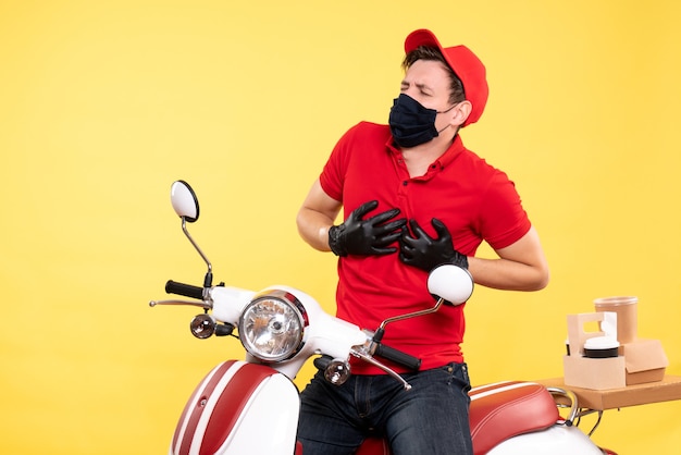 Front view male courier in uniform and mask on yellow 