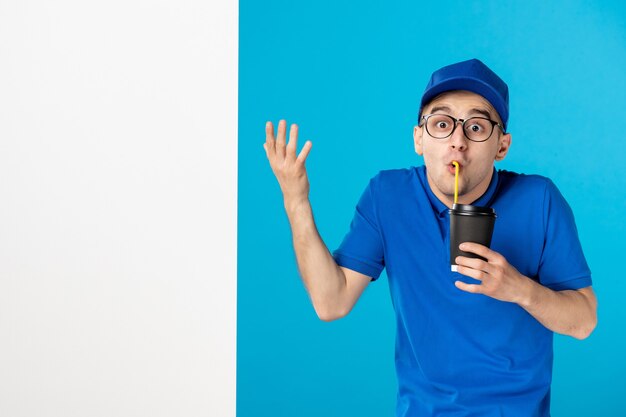 Курьер-мужчина, вид спереди с кофе на синем