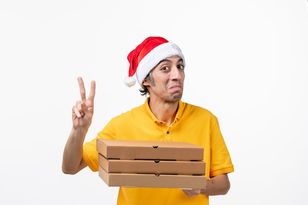 Front view male courier with pizza boxes on white wall service uniform job