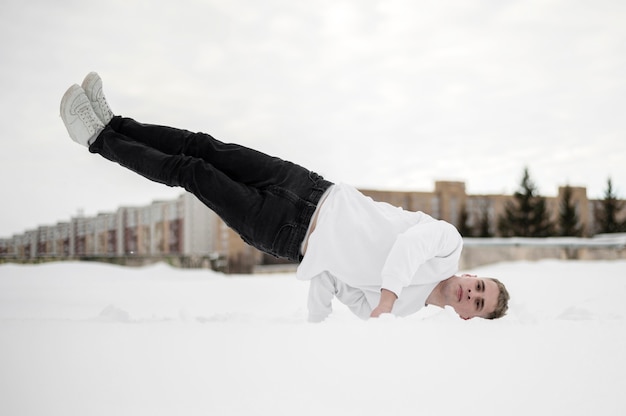 Front view of male dancer balancing his body on one hand