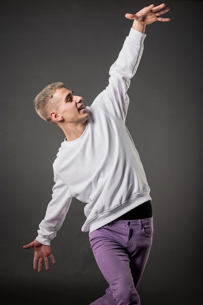 Front view of male dancer in purple jeans dancing