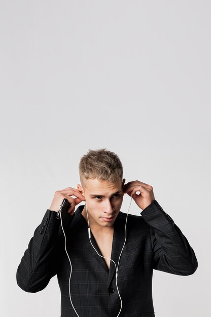 Front view of male dancer in suit putting on headphones with copy space