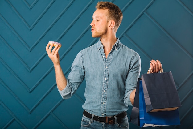 Foto gratuita maschio di vista frontale nelle borse della tenuta del denim