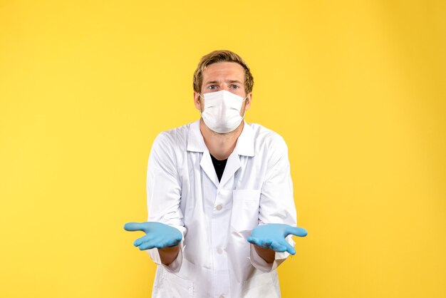 Front view male doctor confused on yellow background health covid- medic pandemic