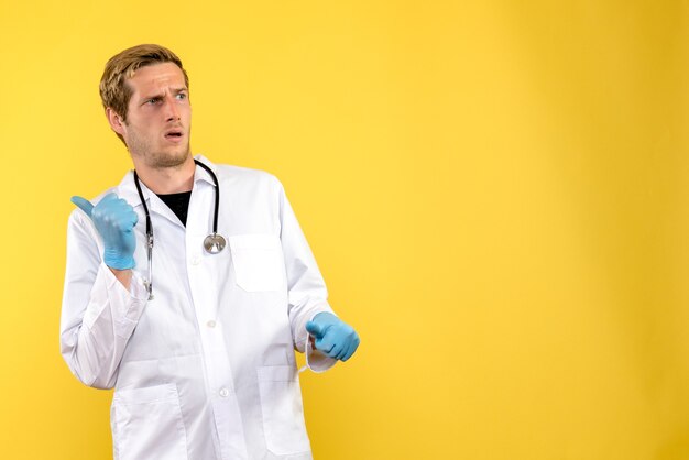 Front view male doctor confused on a yellow background health medic human virus