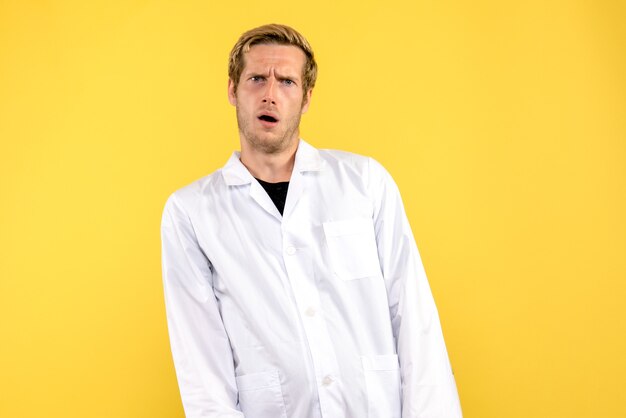 Front view male doctor confused on yellow background medic human pandemic covid
