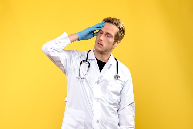Front view male doctor feeling tired on yellow background hygiene medic health hospital