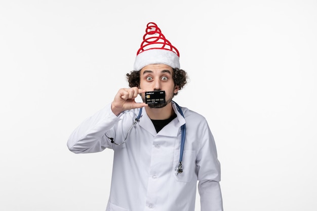 Free photo front view of male doctor holding bank card on white wall