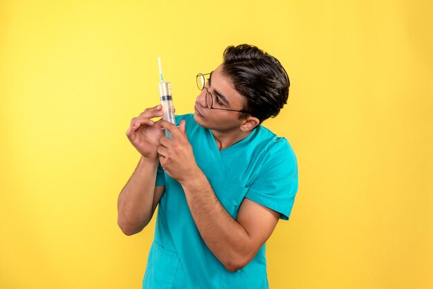 Front view of male doctor holding big injection