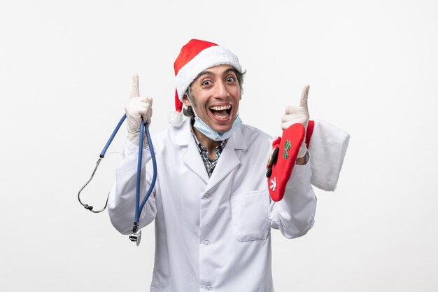 Front view male doctor holding big sock on white wall virus covid holiday health