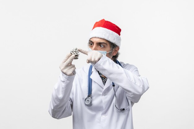 Front view male doctor holding cone on white floor covid- christmas health virus