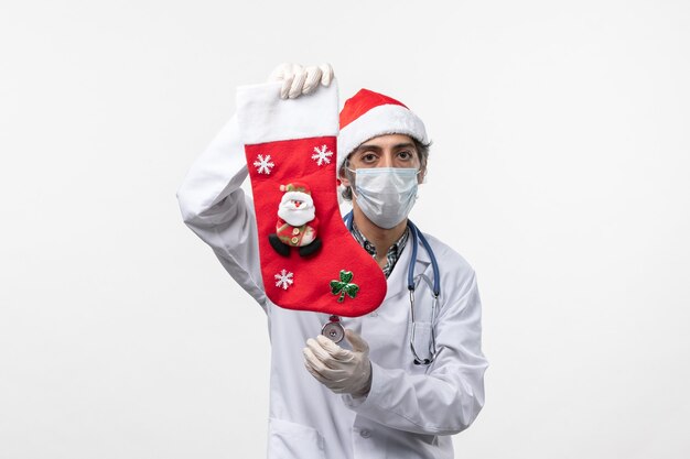 흰색 책상 covid- 크리스마스 바이러스 건강에 휴일 양말을 들고 전면보기 남성 의사