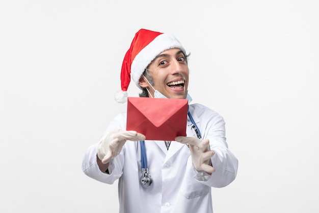 흰 벽 covid- 건강 바이러스에 빨간 봉투를 들고 전면보기 남성 의사