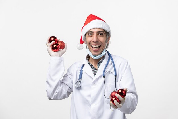 Front view male doctor holding toys on a white wall virus covid emotion health