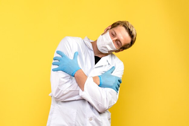 노란색 배경에 자신을 포옹 전면보기 남성 의사 전염병 의료진 covid- 건강