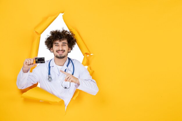 노란색 찢어진 색 의료 의료 바이러스 병원 질병에 은행 카드를 들고 흰색 의료 정장에 전면 보기 남성 의사