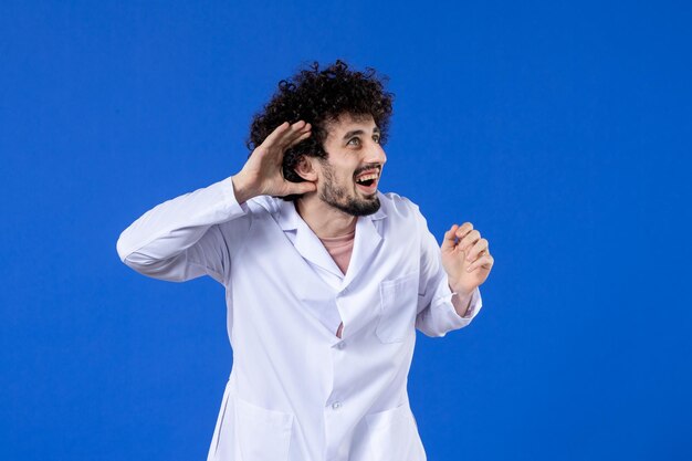 Front view of male doctor in medical suit on blue background vaccine virus covid- pandemic coronavirus health drug hospital