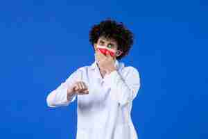 Free photo front view male doctor in medical suit and mask checking time on blue background vaccine hospital virus covid- medicine pandemic drug