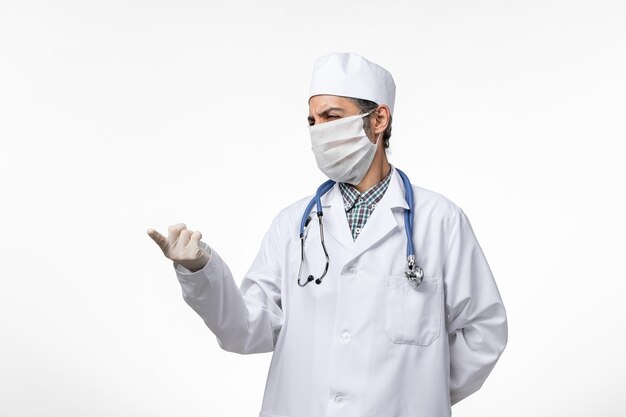 흰색 표면에 코로나 바이러스로 인해 의료 소송 및 마스크 전면보기 남성 의사