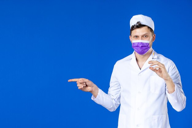 医療スーツとマスク保持ワクチンと青の注射で男性医師の正面図