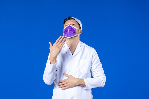 Front view of male doctor in medical suit and purple mask blue 