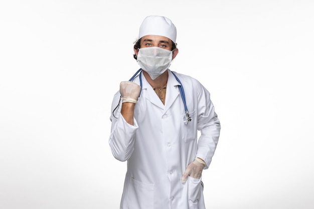 흰 벽 바이러스 질병 covid- pandemic에 대한 covid- 기쁨으로부터 보호하기 위해 멸균 마스크를 착용하는 의료 소송에서 전면보기 남성 의사