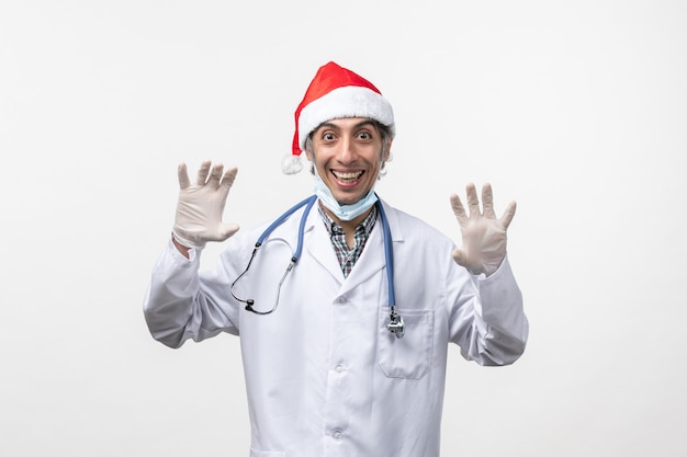 Front view male doctor in medical suit on white desk virus holiday covid- emotion