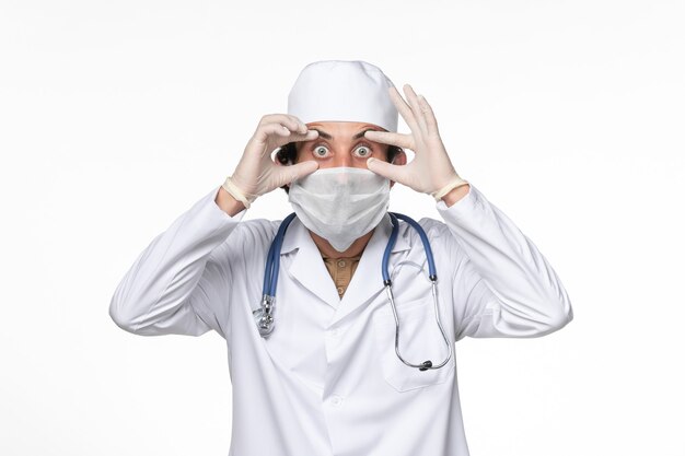 밝은 흰색 벽 코로나 바이러스 바이러스 전염병 의학에서 covid-로부터 보호하기 위해 마스크와 의료 소송에서 전면보기 남성 의사