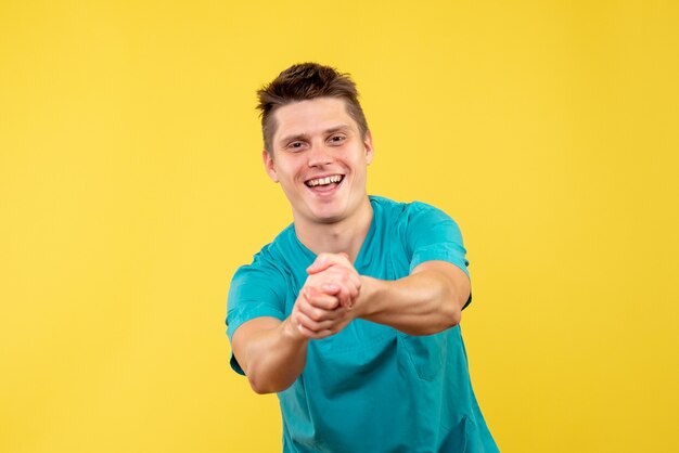 Front view of male doctor in medical suit on yellow wall