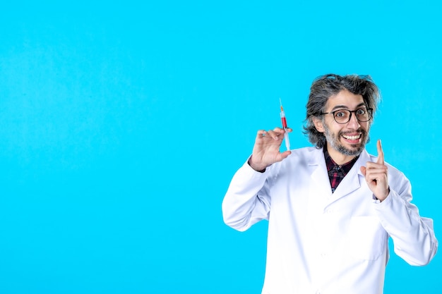 Front view male doctor preparing injection on blue