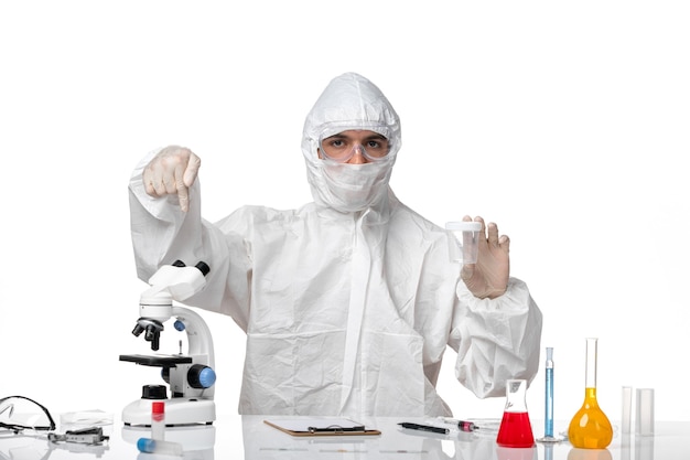 Вид спереди мужчина-врач в защитном костюме, держащий пустую фляжку на белом пространстве