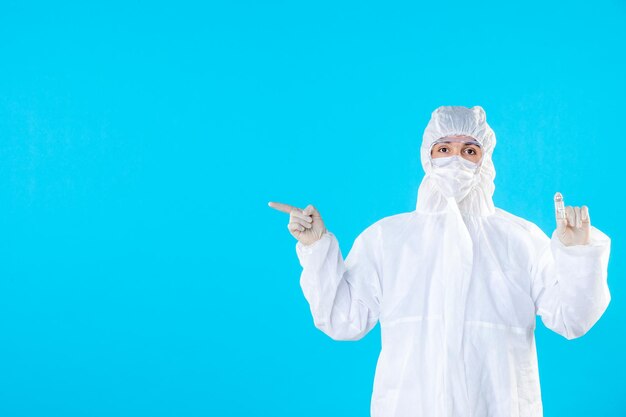 Front view male doctor in protective suit and mask on blue