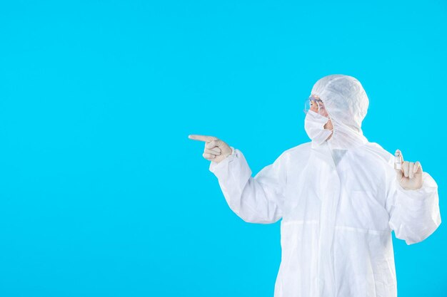 Front view male doctor in protective suit and mask on blue