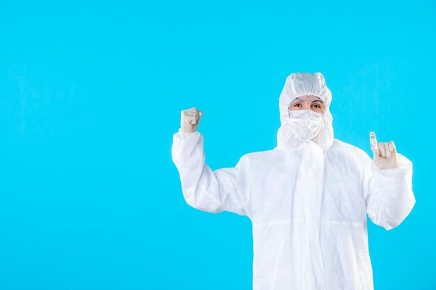 Вид спереди мужчина-врач в защитном костюме и маске на синем